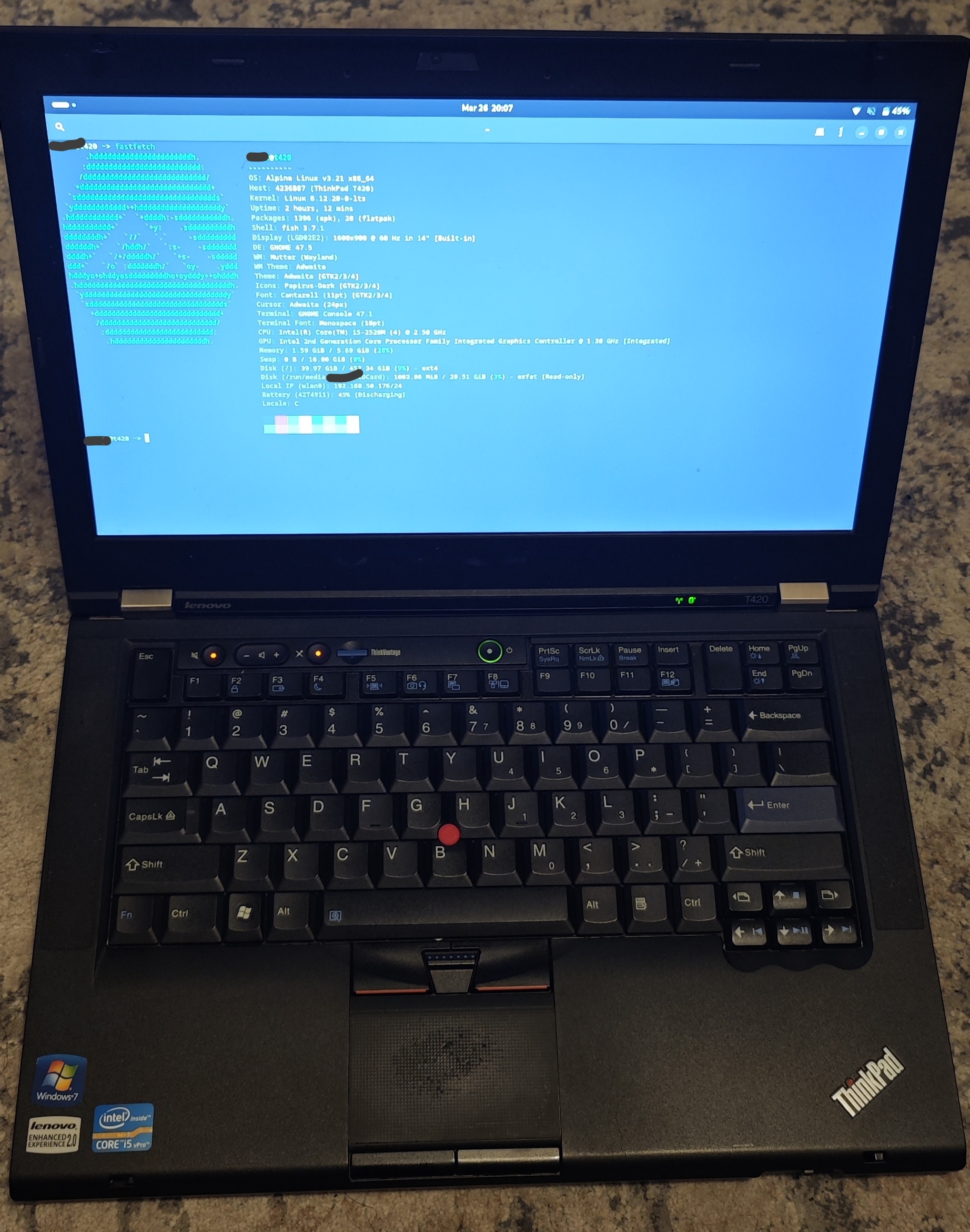 Photo of the thinkpad with the terminal running fastfetch